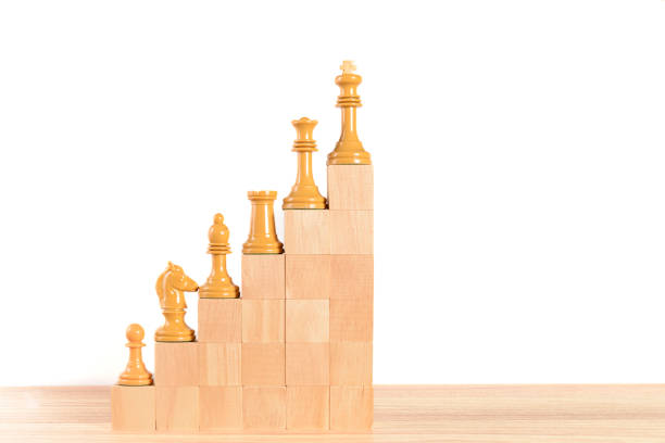 istock White chess pieces on a wooden block staircase. 1434376699