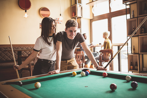 Couple playing pool in the pub