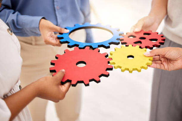 istock Business, collaboration and gears for strategy success and team unity and support for a project. Hands of a group of corporate employees with a common goal in a partnership for innovation 1434377677