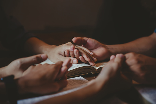 Christian group are praying to god with the bible and sharing the gospel.