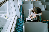 Young traveler sleeping at airport waiting area