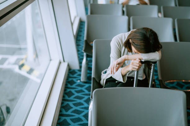 Young traveler sleeping at airport waiting area stock photo