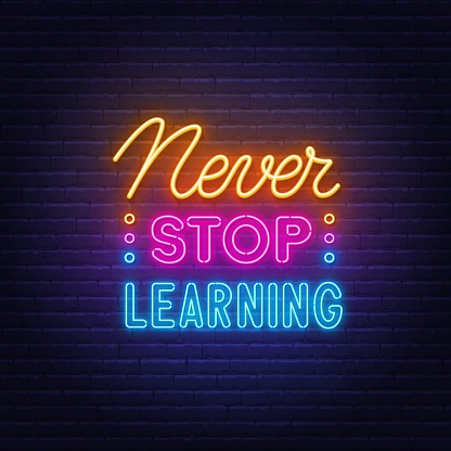 Never Stop Learning neon quote on a brick wall. Inspirational glowing lettering.