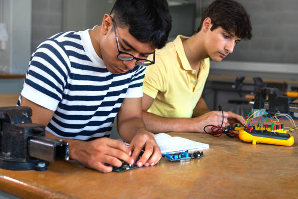 istock Male multiracial teen high school students working together on a project in electronics class. Education. Cooperation 1434378394