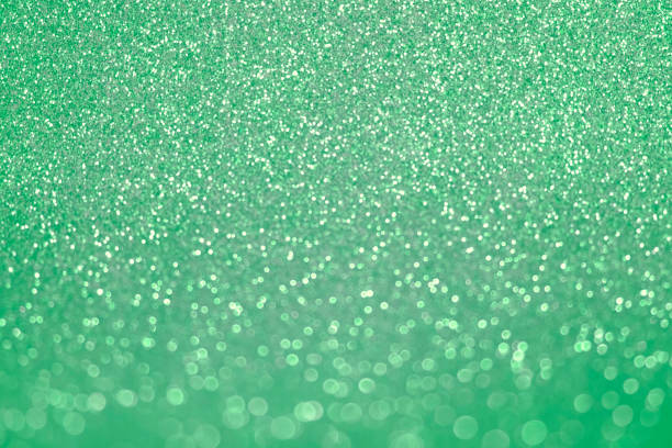 Abstract Glitter Background. Green Texture Sparkling Shiny Paper for Christmas Holiday. Seasonal Wallpaper Decoration. Greeting and Wedding Invitation Card Design Mock Up. Sparkle Lights and Bokeh Backdrop. Festive and holiday golden background for text. Defocused abstract backdrop with sparkling glitter and bokeh. Glitzy, glossy effect. Festive background. Mockup