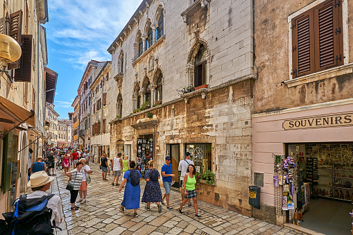Porec, Croatia - August 30, 2022: Pedestrians on Dekumanva Street in Porec.