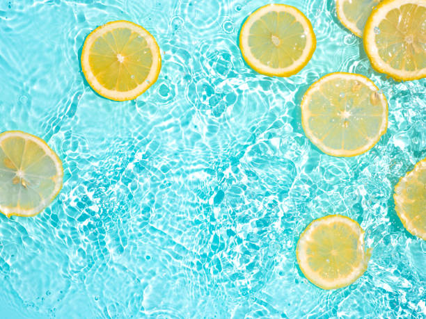 Lemon slices in clean transparent water, blue bg