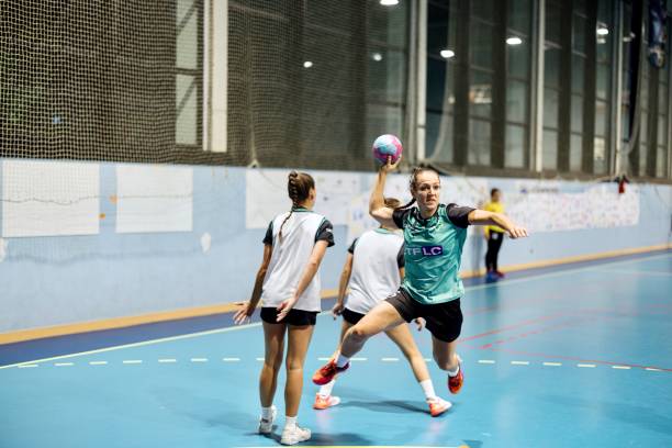 Group of women handball players in action. Female handball players are playing a match at training handball stock pictures, royalty-free photos & images