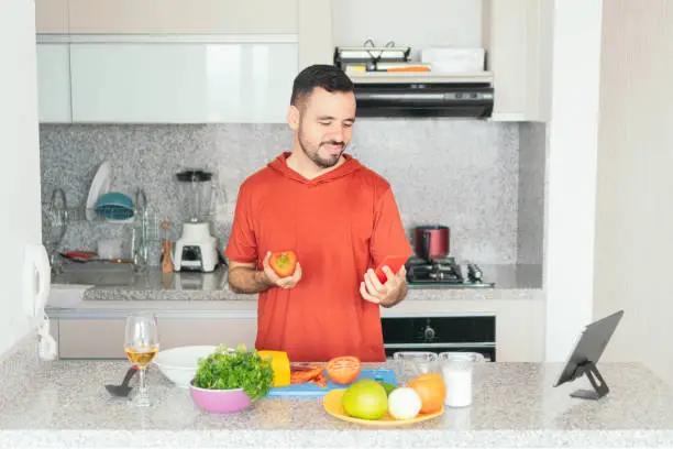 Photo of Man preparing breakfast while using cell phone at home