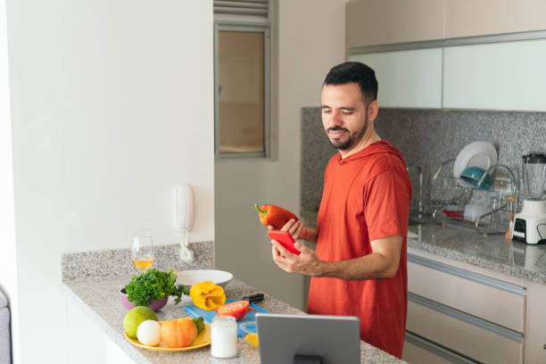 istock Young man uses smartphone in the kitchen 1434392138
