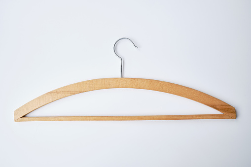 Wooden clothes hanger on a light background. Smart consumption or sales concept
