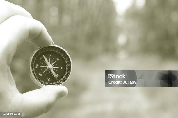 Classic Compass In Hand On Natural Background Stock Photo - Download Image Now - Guidance, Adult, Adults Only