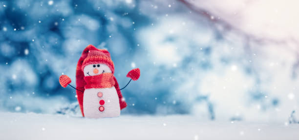 istock Little knitted snowman on the white snow on blue background. 1434397684