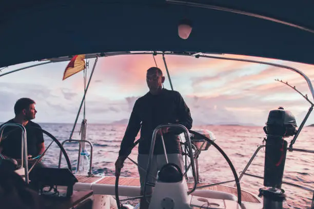 Man sailing on sunset sea.