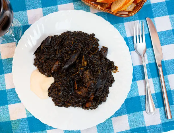 Photo of Arroz negro - spanish recipe, black paella with cuttlefish on plate