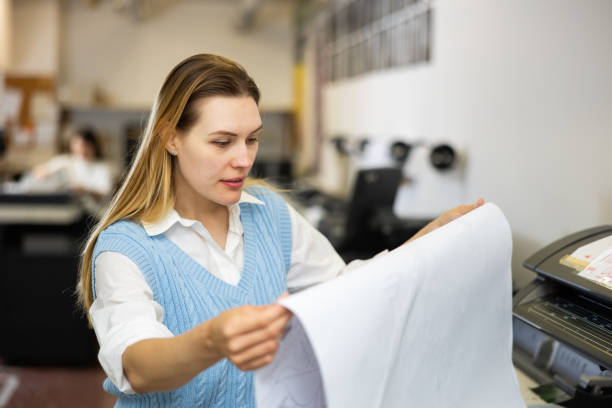 istock Printing establishment worker examining large piece of paper 1434404707