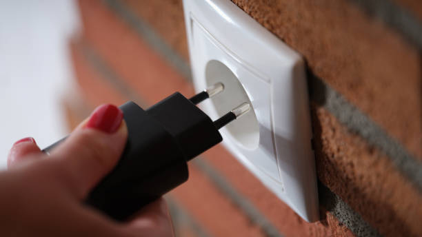 istock Closeup of woman holding hand and inserting plug into socket 1434408788