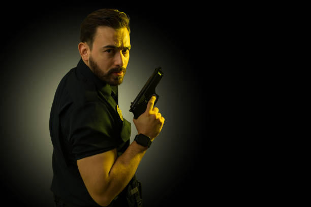 istock Handsome police agent holding his weapon while on duty 1434409136