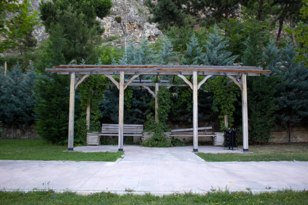 istock Empty benches under the wooden gazebo. Big mountain cliffs and trees in the background 1434417351