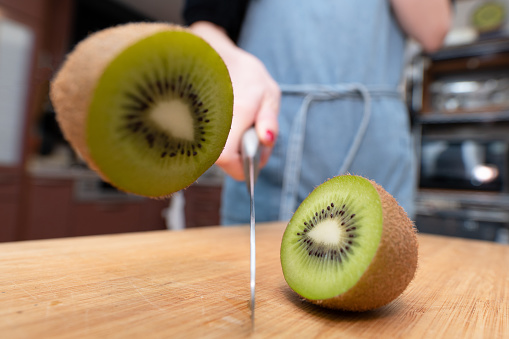 woman cutting kiwi fruit