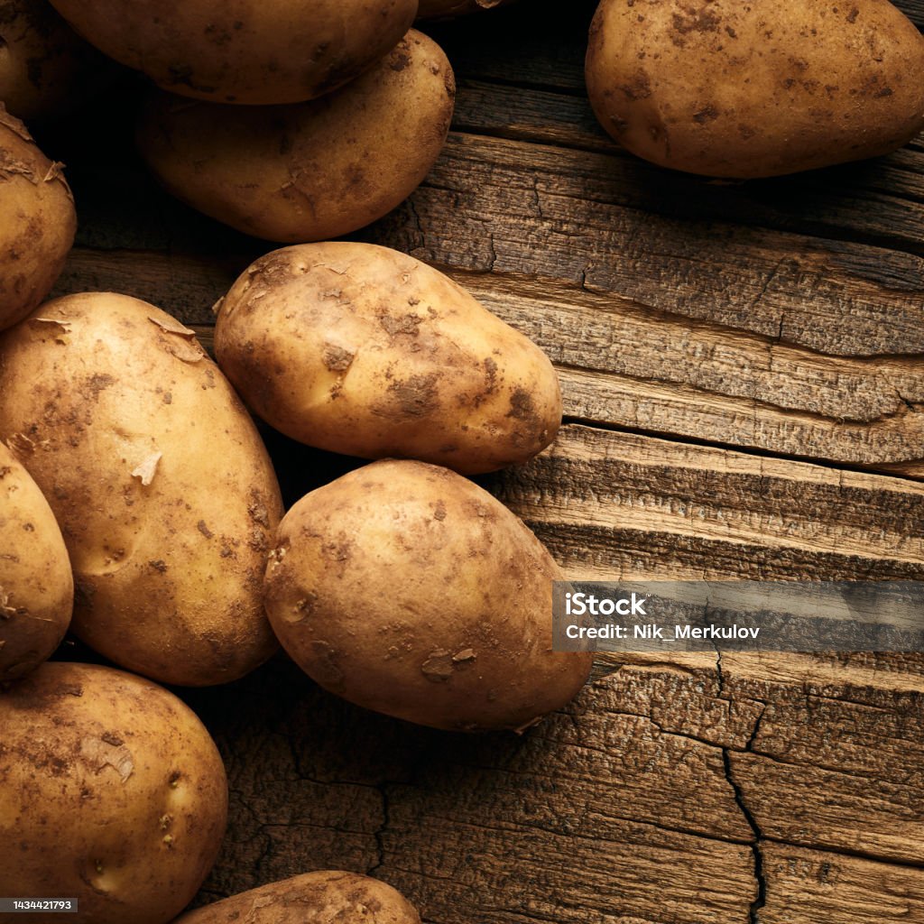 Potatoes over wooden background Potatoes over wooden vintage background Dirt Stock Photo