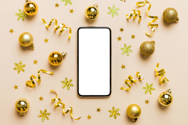 istock Christmas online shopping from home phone with blank white display top view. smart mobile with copy space on colored background with Christmas decorations balls,. Winter holidays sales background 1434427263