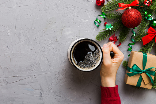 Woman holding cup of coffee. Woman hands holding a mug with hot coffee. Winter and Christmas time concept.