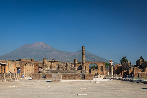 The ruins of Pompeii with a clear blue sky over Mount Vesuvius in Italy.