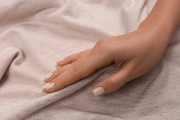istock Woman touching soft beige fabric, closeup view 1434432074