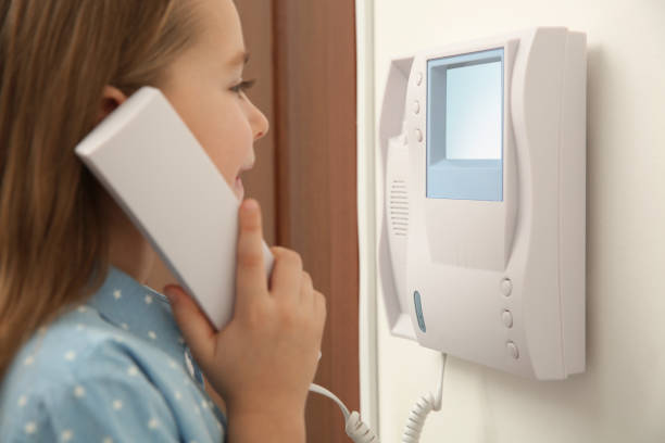 istock Cute little girl answering intercom call indoors, closeup 1434432521