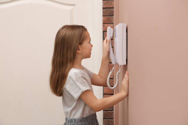 istock Cute little girl answering intercom call indoors 1434432730