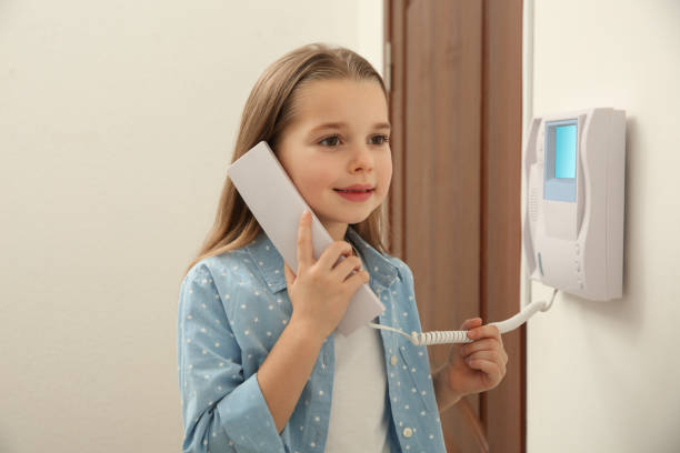 istock Cute little girl answering intercom call indoors 1434432833