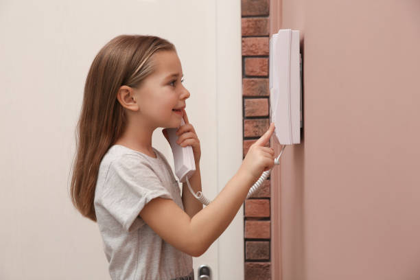 istock Cute little girl answering intercom call indoors 1434433067