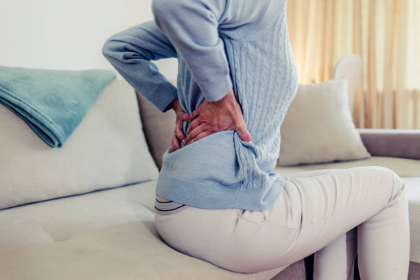 istock Unhappy grey haired mature woman with closed eyes touching, massaging back. 1434433764
