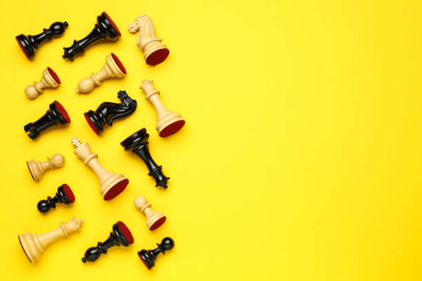 istock Many different chess pieces on yellow background, flat lay. Space for text 1434434613