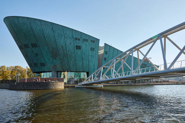 steel walking bridge at the nemo museum science center modern green building in amsterdam - nemo museum imagens e fotografias de stock