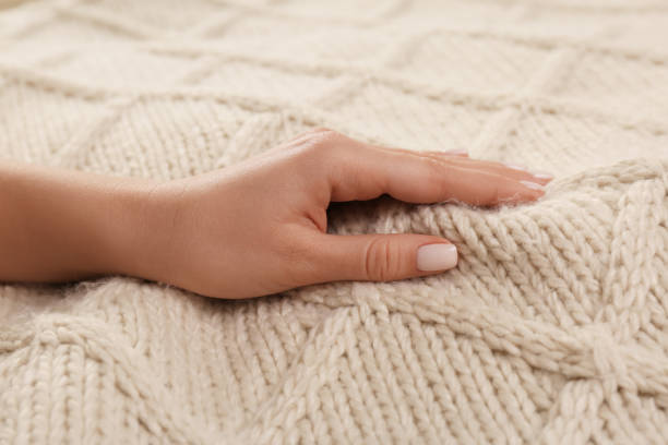 istock Woman touching soft beige knitted fabric, closeup 1434436046