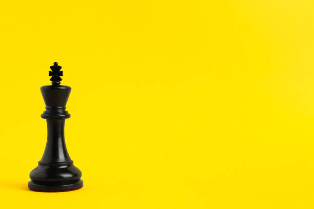 istock Black king on yellow background, space for text. Chess piece 1434436804