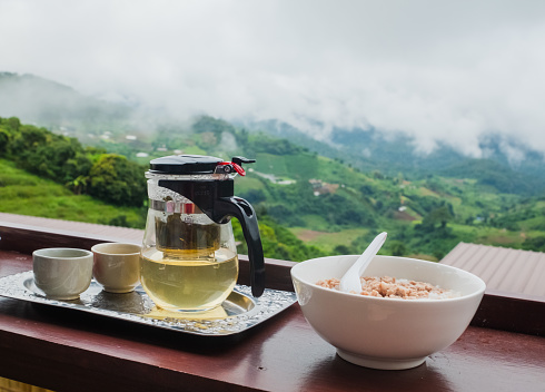 The breakfast set had pork porridge and a tea set side by side with mountains in the background and flares.