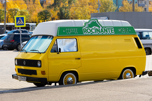 Krasnoyarsk, Russia - 23 September, 2022: Yellow Volkswagen Transporter T3 minibus car with mobile coffee shop on city street. Food van truck. Street food business.