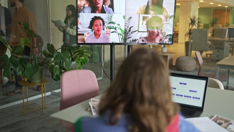 Business woman having online briefing with team in a hybrid office