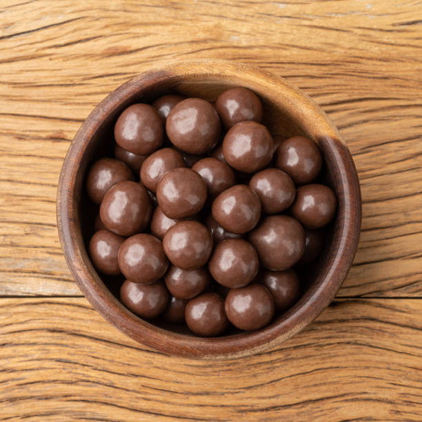 istock Chocolate malted balls in a bowl over wooden table 1434439564