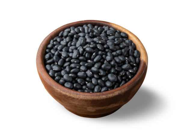 istock Raw black beans on a wooden bowl isolated over white background 1434439609