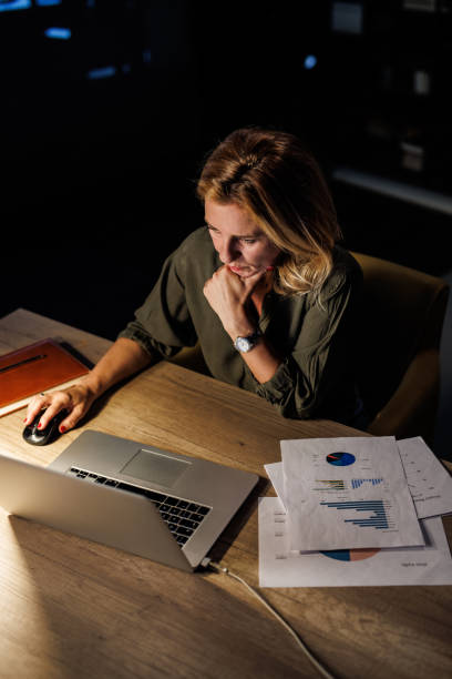 istock Portrait of diligent businesswoman using laptop at her desk and analyzing project paperwork 1434440103