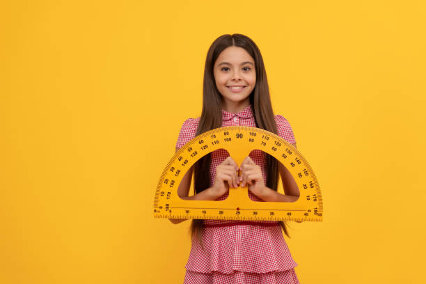 istock cheerful teen girl study math in school hold protractor ruler, geometry 1434440712