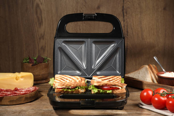 istock Modern grill maker with sandwiches and different products on wooden table 1434442643