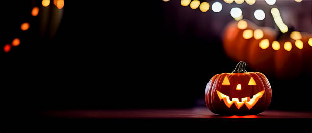istock Cut out Halloween Pumpkin glowing at night with blurry lights in dark background 1434442747