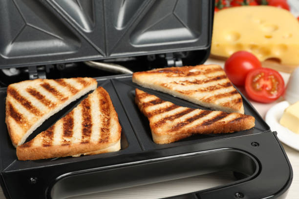 istock Modern sandwich maker with bread slices, closeup 1434442993