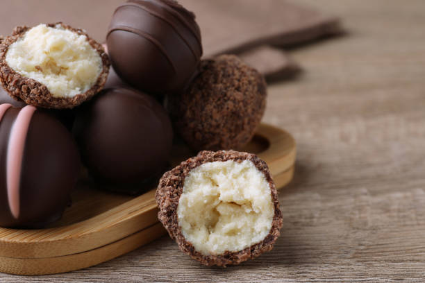 istock Many different delicious chocolate truffles on wooden table, closeup. Space for text 1434445213