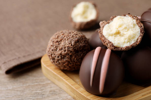 istock Many different delicious chocolate truffles on wooden table, closeup. Space for text 1434446022